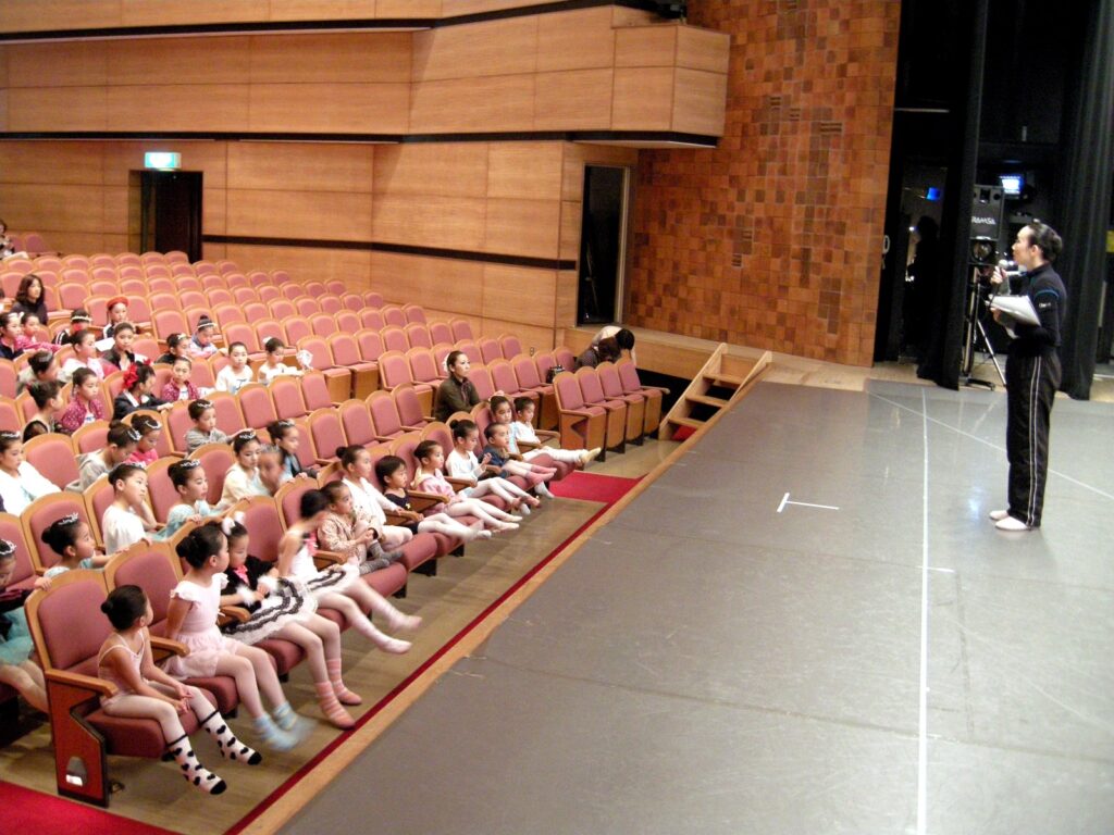 舞台前に先生の説明を聞く安城バレエの子どもたち