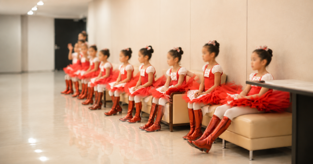 赤い衣裳の子どもたちが並んで待っている安城バレエの子どもたち